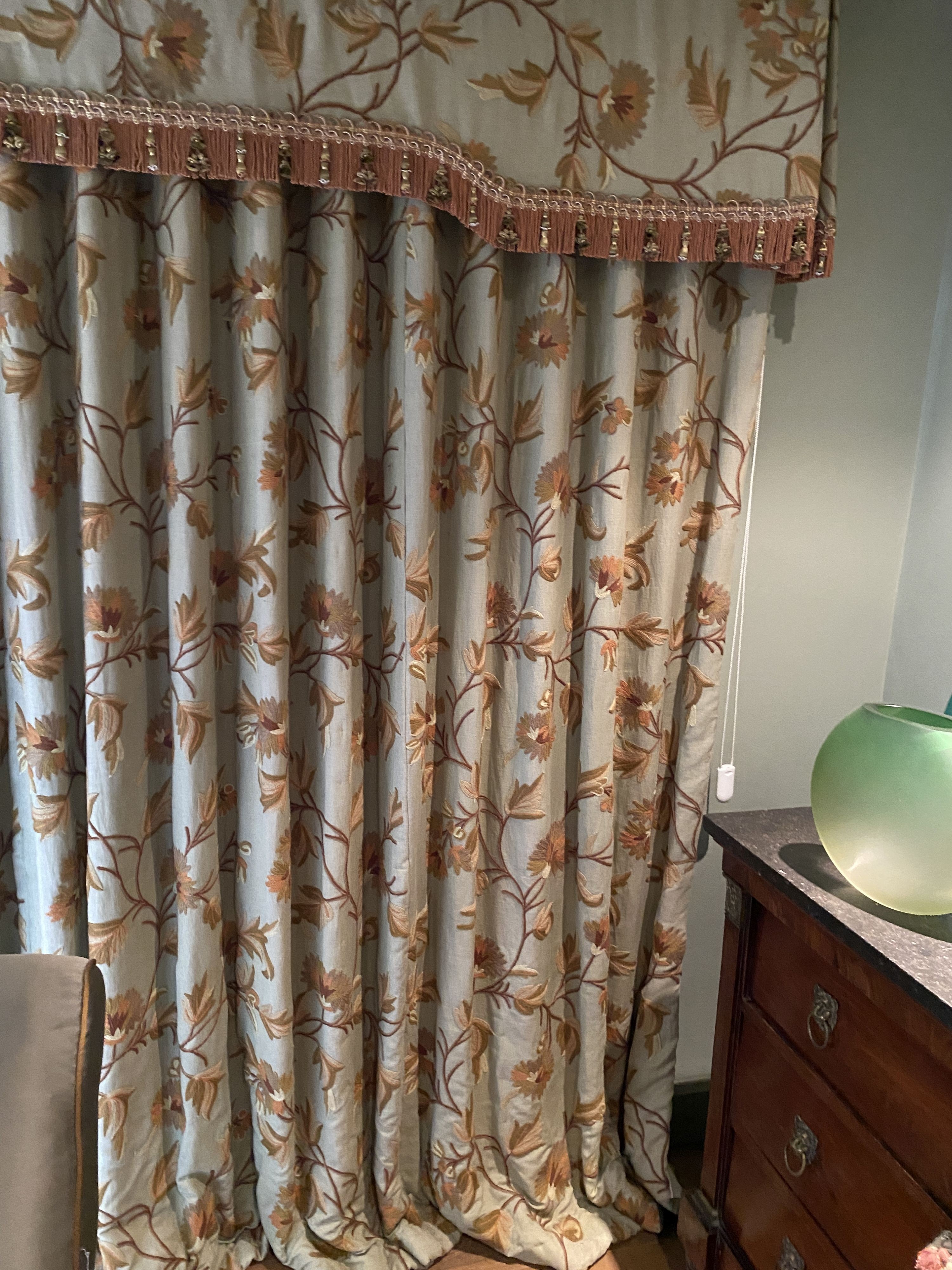 A pair of eau de nil linen curtains with floral crewel work decoration, and matching two piece pelmet, drop 230cm, generously made to fit an aperture of 3.8m